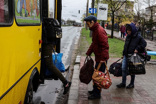 People board a bus leaving Severodonetsk, in eastern Ukraine"s Donbass region, on April 13, 2022 as Russian troops intensified a campaign to take the strategic port city of Mariupol, part of an anticipated massive onslaught across eastern Ukraine. (Credit: RONALDO SCHEMIDT / AFP)