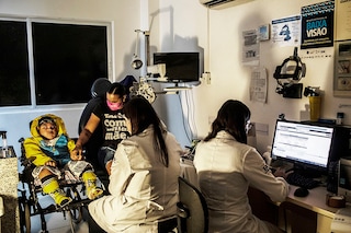 Ana Ipojuca holds the hand of her son Christian, 6, as an opthamologist checks his eyes in Recife, Brazil, June 2, 2022. Some of the babies born with devastating defects by mothers infected with the mosquito-borne Zika virus during a 2015-2016 outbreak are now 7, and families in this scrappy corner of Brazil are struggling to get help for their children, whose mysterious condition constantly presents new challenges. (Dado Galdieri/The New York Times)
