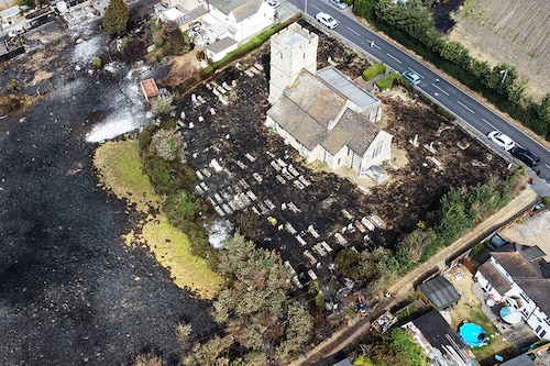 WENNINGTON, GREATER LONDON - JULY 20: An aerial view shows the scorched graveyard around a church following a large blaze the previous day, on July 20, 2022 in Wennington, Greater London. A series of fires broke out across England yesterday as the UK experienced a record-breaking heatwave. Temperatures in many places reached 40c and over. Image: Leon Neal/Getty Images WENNINGTON, GREATER LONDON - JULY 20: An aerial view shows the scorched graveyard around a church following a large blaze the previous day, on July 20, 2022 in Wennington, Greater London. A series of fires broke out across England yesterday as the UK experienced a record-breaking heatwave. Temperatures in many places reached 40c and over. Image: Leon Neal/Getty Images