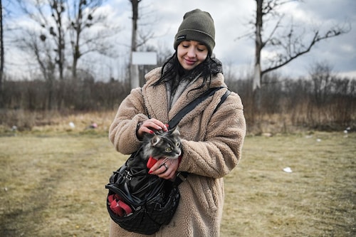 Lera, a young refugee from Ukraine holds her cat at the outside the temporary shelter and relocation center near Przemysl, south-eastern Poland on March 10, 2022. The UN says at least 2.2 million people have fled Ukraine, with more than half now in Poland. It has called the exodus Europe"s fastest-growing refugee crisis since World War II. (Credit: Louisa GOULIAMAKI / AFP)