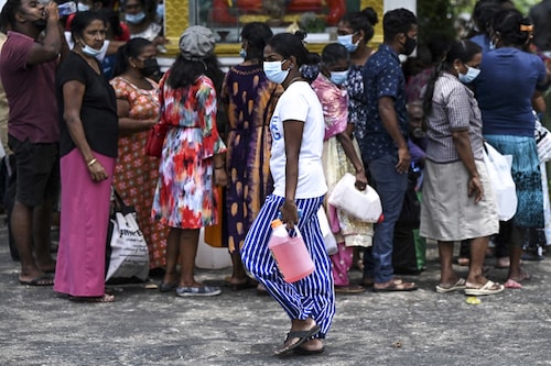 People stand in a queue to buy kerosene for home use at a service station in Colombo, March 25, 2022 . As Sri Lankans faint in day-long queues for fuel and swelter through stifling evening blackouts by candlelight, anger is mounting over the worst economic crisis in living memory. (Credit: Ishara S. Kodikara / AFP) People stand in a queue to buy kerosene for home use at a service station in Colombo, March 25, 2022 . As Sri Lankans faint in day-long queues for fuel and swelter through stifling evening blackouts by candlelight, anger is mounting over the worst economic crisis in living memory. (Credit: Ishara S. Kodikara / AFP)