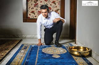 Rudra Chatterjee views the ‘Brocade Garden’, a hand-knotted silk-and-wool rug in indigo by Tarun Tahiliani. A part of the Antique Frames collection designed by Tahiliani for Obeetee, the design is an ode to the biodiverse gardens of the Mughal era.<br>Image: Debarshi Sarkar for Forbes India