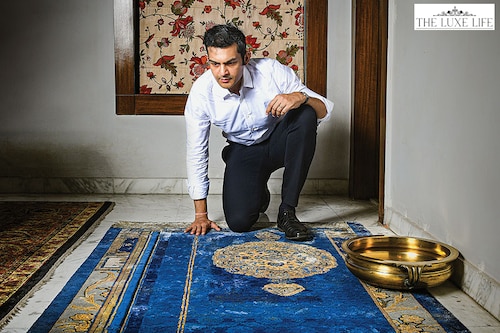 Rudra Chatterjee views the ‘Brocade Garden’, a hand-knotted silk-and-wool rug in indigo by Tarun Tahiliani. A part of the Antique Frames collection designed by Tahiliani for Obeetee, the design is an ode to the biodiverse gardens of the Mughal era.<br>Image: Debarshi Sarkar for Forbes India Rudra Chatterjee views the ‘Brocade Garden’, a hand-knotted silk-and-wool rug in indigo by Tarun Tahiliani. A part of the Antique Frames collection designed by Tahiliani for Obeetee, the design is an ode to the biodiverse gardens of the Mughal era.<br>Image: Debarshi Sarkar for Forbes India
