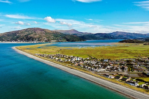 An aerial photograph taken on August 30, 2022 shows the coast and the village of Fairbourne, on Wales" northwest coast, which is predicted to flood due to the rising level of the sea. Image: Paul ELLIS / AFP