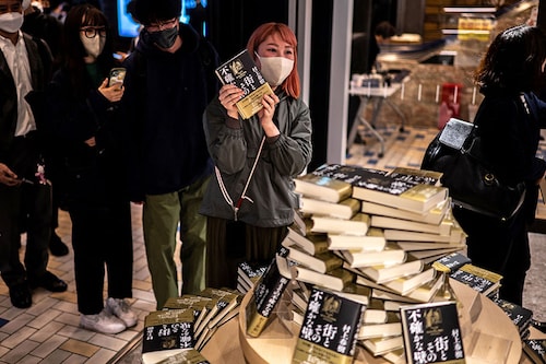 People line up to purchase the fresh copies of Japanese writer Haruki Murakami"s new novella "The City and Its Uncertain Walls."
Image: Philip Fong / AFP