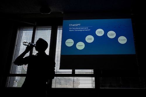 High school English and philosophy teacher Eric Vanoncini is seen in silhouette drinking water prior to leading a workshop on ChatGPT bot
Image: Fabrice Coffrini / AFP