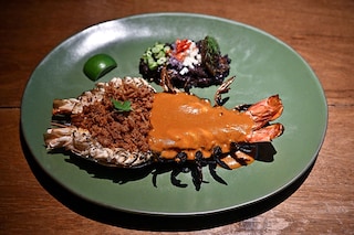 This photo taken on June 23, 2023 shows a shrimp paste rice-inspired river prawn dish by Michelin-starred Thai chef Thitid "Ton" Tassanakajohn at his fine dining restaurant Le Du, in Bangkok. Image  Credit: Lillian SUWANRUMPHA / AFP