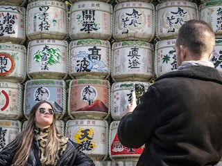 People take photographs of a display of sake barrels at Meiji Shrine in Tokyo.
Image: Yuichi Yamazaki / AFPÂ©