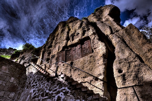 The cave church within the grounds of Geghard Monastery proudly displays four medieval khachkars carved in the 12th century, embedded in its walls amidst the mountainous terrain
Image: Shutterstock