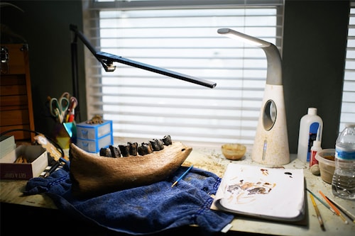 Lauren McClain"s job begins at her home workshop near Houston, Texas, where she carefully clears away dirt stuck to the more than 60-million-year-old remains using a tiny drill with an air compressor, similar to a dentist"s tool. Image credit: Photography Mark Felix / AFPÂ©