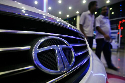 Men walk inside a Tata Motors showroom