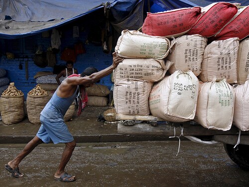 A labourer pushes a handcart loaded with sacks containing tea packets, towards a supply truck at a wholesale market in Kolkata, India, June 26, 2015. For years Indian businesses have lobbied for a nationwide sales tax, hoping to replace a chaotic structure that inflates costs and halts their trucks at state borders for duty payments, and to unify the country into one of the world's largest single markets. But after political compromises that finally got a goods and services tax (GST) bill before parliament, they have turned wary. Picture taken June 26. REUTERS/Rupak De Chowdhuri - RTX1IO22