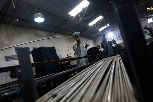 An employee holds a steel rod as he works on the production line inside Hallmark steel factory in Bhiwadi in the desert Indian state of Rajasthan September 30, 2013. India's prolonged economic slide has affected many companies in India, but small and medium-sized firms have been hit the most because of their more limited access to finance. REUTERS/Adnan Abidi (INDIA - Tags: BUSINESS EMPLOYMENT) - RTR3FKJ3