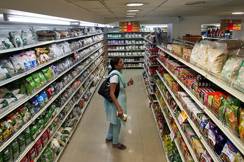 A customer looks at consumable goods before buying them at a supermarket in the southern Indian city of Hyderabad December 1, 2011. Image: Krishnendu Halder/ Reuters