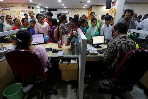 People stand in a queue to deposit 500 and 1000 Indian rupee banknotes inside a bank in the northern city of Kanpur, India, November 10, 2016. REUTERS/Adnan Abidi - D1BEUMAGAJAB