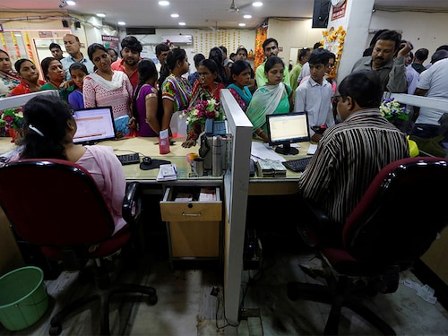 People stand in a queue to deposit 500 and 1000 Indian rupee banknotes inside a bank in the northern city of Kanpur, India, November 10, 2016. REUTERS/Adnan Abidi - D1BEUMAGAJAB