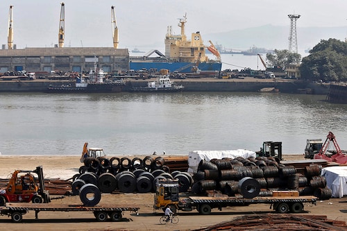 A worker rides his bicycle past steel rims in a dockyard at Mumbai Port Trust in Mumbai November 17, 2014. REUTERS/Shailesh Andrade/File Photo - S1BETTGTLOAA