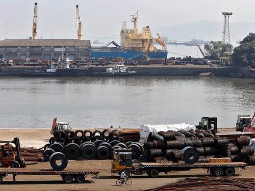 A worker rides his bicycle past steel rims in a dockyard at Mumbai Port Trust in Mumbai November 17, 2014. REUTERS/Shailesh Andrade/File Photo  - S1BETTGTLOAA