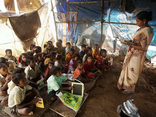 MUMBAI, INDIA  SEPTEMBER 7, 2009: Education - School for Ragpickers Children - Kavita Sopane teaches the children of ragpickers the alphabet in their makeshift classroom in Durgawadi slum at Mulund Dumping ground. (Photo by Manoj Patil/Hindustan Times via Getty Images)
