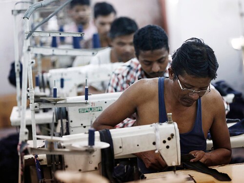 Employees sew clothes at a garment factory in New Delhi September 29, 2014. India's cotton and apparel exports are set to climb by around 10 percent this year as higher wages, political instability and concerns about workplace conditions in other producing markets steer international buyers toward Indian exporters, industry officials said. REUTERS/Adnan Abidi (INDIA - Tags: BUSINESS TEXTILE) - GM1EA9T1JAW01