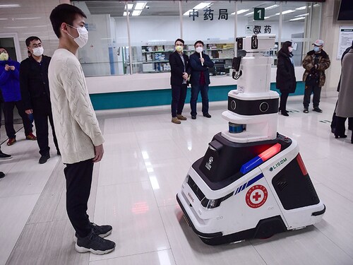 This photo taken on February 26, 2020 shows a patrol robot - used to check temperatures, identities and disinfect people - checking the temperature of a visitor at a hospital in Shenyang in China's northeastern Liaoning province. - The hospital uses the robot to reduce the pressure on front-line medical staff and to avoid cross infections from the COVID-19 coronavirus. (Photo by STR / AFP) / China OUT (Photo by STR/AFP via Getty Images)