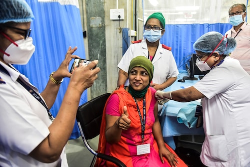 BMC medical staffer Pragati Dalvi, poses for a photo while receiving a Covid-19 vaccine shot at KEM hospital, on January 16, 2021 in Mumbai, India; Image: Anshuman Poyrekar/Hindustan Times via Getty Images