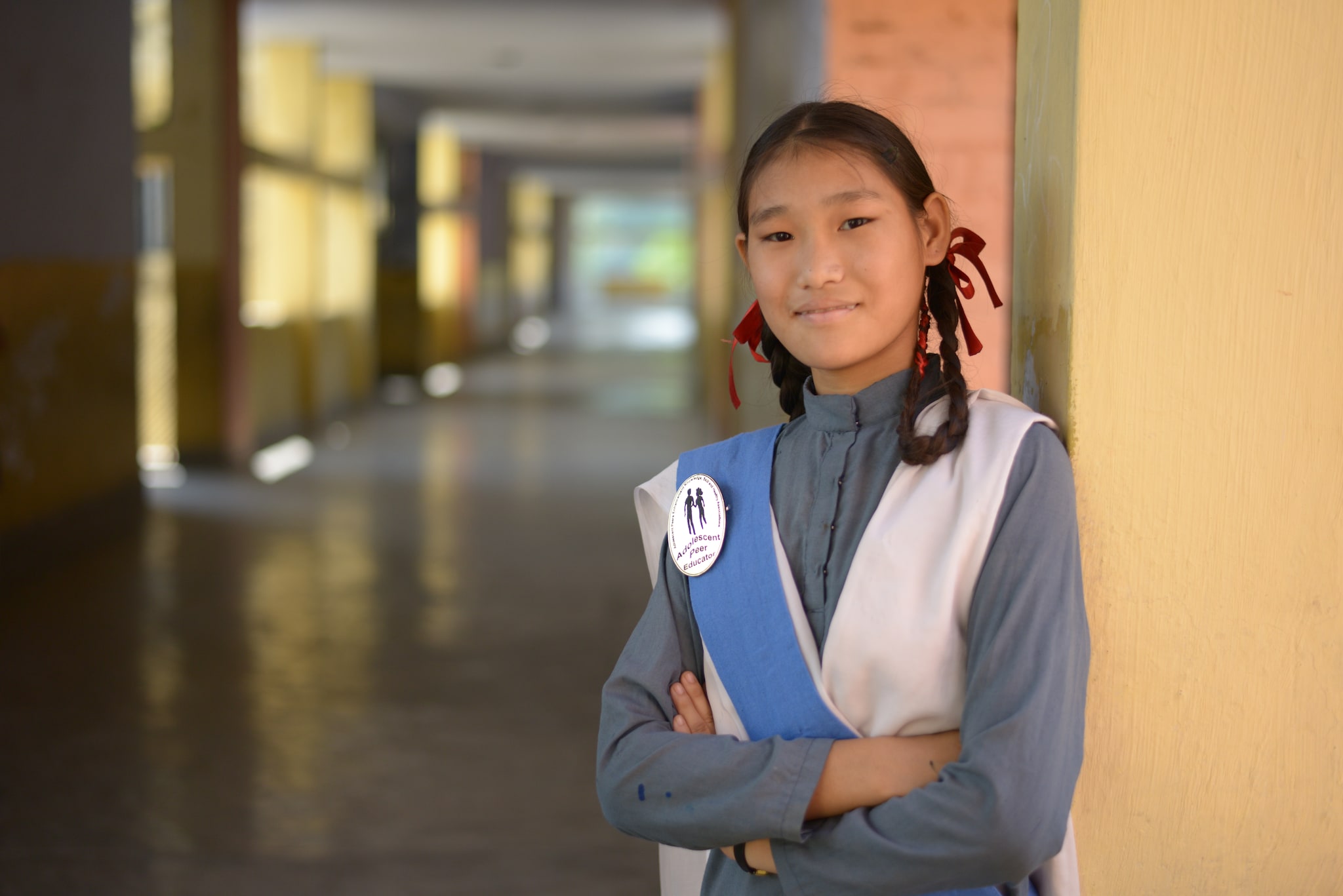 An Adolescent Peer Educator stands proudly after attending her orientation and training