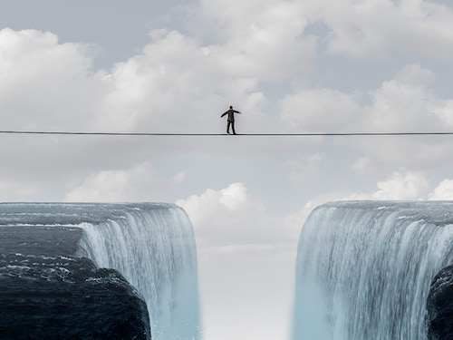 Business challenge and financial risk or balancing act concept or brave businessman courage to take chances as a person walking on a highwire or high tightrope crossing in a 3D illustration style.
