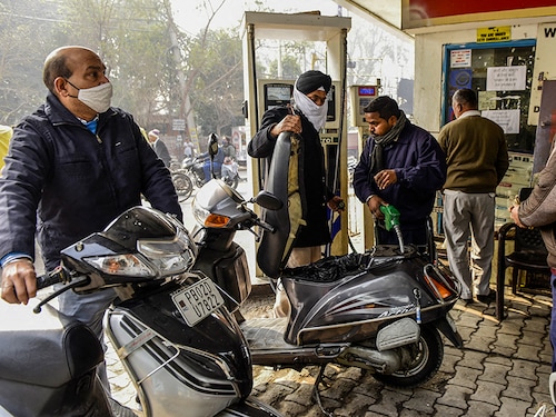 A fuel pump attendant fills a motorbike with petrol at a gas station following a hiked of petrol and diesel prices by state-run Oil Marketing Companies (OMC), in Amritsar on February 13, 2021 (Photo by NARINDER NANU / AFP)
