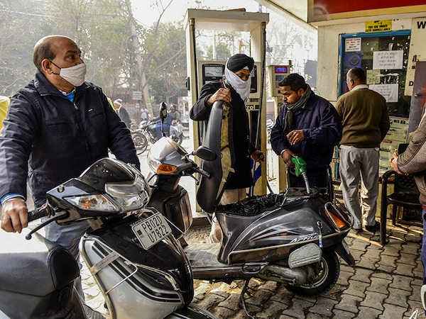 A fuel pump attendant fills a motorbike with petrol at a gas station following a hiked of petrol and diesel prices by state-run Oil Marketing Companies (OMC), in Amritsar on February 13, 2021 (Photo by NARINDER NANU / AFP)
