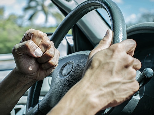 Angry driver honking and beeping the horn. Road rage.