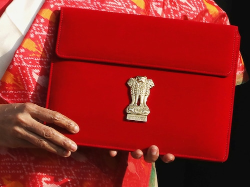 India's Finance Minister Nirmala Sitharaman holds up a folder with the Government of India logo, while India's Chief Economic Advisor Krishnamurthy Subramanian looks on (at rear), as she leaves her office to present the federal budget in the parliament in New Delhi, India, February 1, 2021. REUTERS/Anushree Fadnavis - RC2GJL9ZFN61
