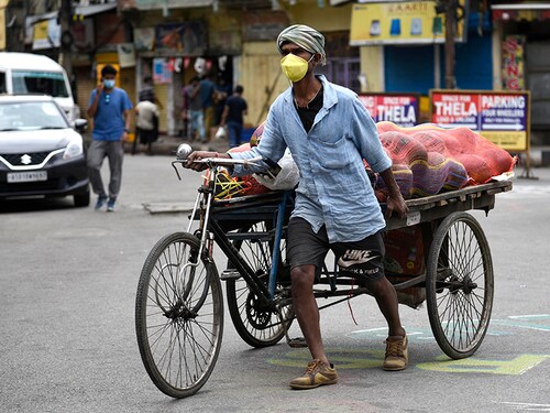 Guwahati, Assam, India. 22 April 2020.  A labourer wearing face mask pulling  a cart, during the nationwide lockdown to curb the spread of coronavirus.