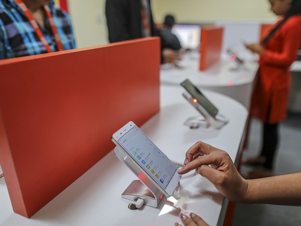 Employees use Xiaomi Corp. smartphones on display in a lab of a call center servicing the company in Bengaluru, India, on Friday, March 31, 2017. Once compared with Apple Inc. for its sleek smartphones and charismatic leadership, Chinese startup Xiaomi is seeking an image makeover as it tries to recover from a sales-growth slide. Photographer: Dhiraj Singh/Bloomberg via Getty Images