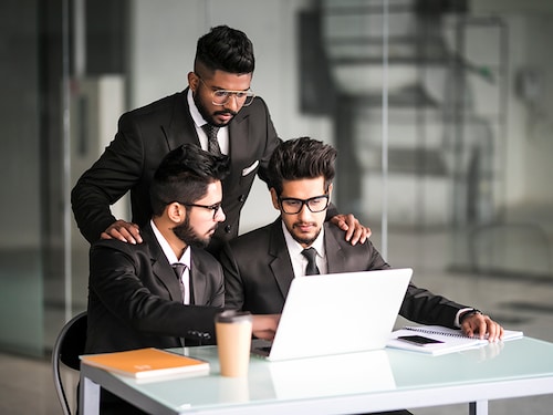 Discussing new project. Three young business people discussing something while looking at the computer monitor together