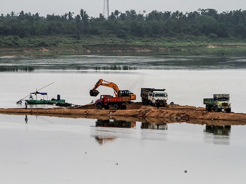 Trucks and other machine are seen inside the Kuakhai river as collects sands from the river to transport it to construction sites just outskirts of the eastern Indian state Odisha's capital city Bhubaneswar, on July 26, 2019. (Photo by STR/NurPhoto via Getty Images)