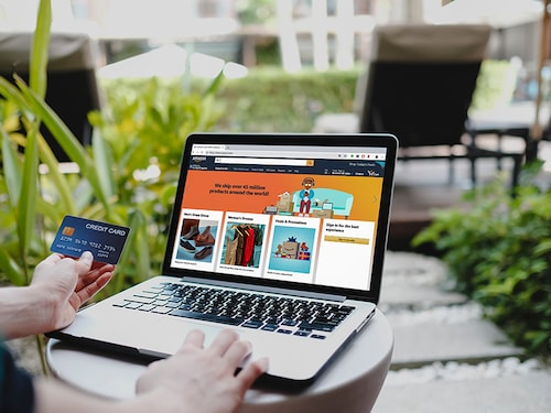 BANGKOK,THAILAND - JUNE 6, 2020 :A woman using laptop showing Amazon logo and credit card shopping online. Amazon.com, Inc. American international electronic commerce company.