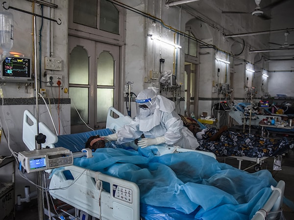 MUMBAI, INDIA - MAY 27: Healthcare worker Shama Shaikh, 53, cares for a patient who has Covid-19 in an ICU ward at the government-run St. George hospital on May 27, 2021 in Mumbai, India. India's prolonged and devastating wave of Covid-19 infections has gripped cities and overwhelmed health resources. (Photo by Fariha Farooqui/Getty Images)