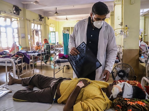 A doctor assists a Covid-19 coronavirus patient with Black Fungus, a deadly and rare fungal infection, as he receives treatments at the NSCB hospital in Jabalpur, on May 20, 2021. (Photo by Uma Shankar MISHRA / AFP)