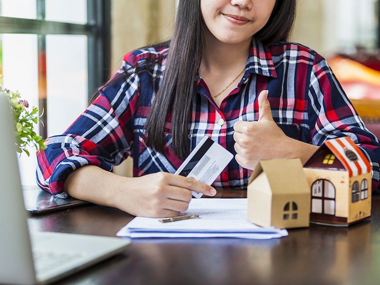 casual business woman celebrate with credit card her is success after Banks approve loans to buy homes while using laptop computer find out the finance investment investing. business concept