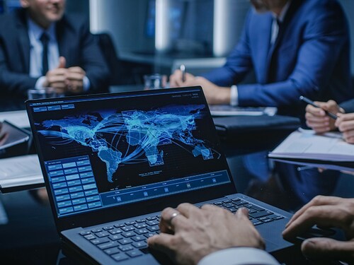 On the Table Laptop Showing World Data Flow: Team of Politicians, Corporate Business Leaders and Lawyers Sitting at the Negotiations Table in the Conference Room, Trying to Come to an Agreement.