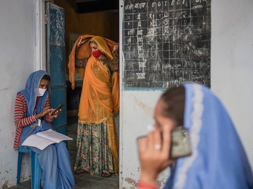 AAKHTADI, INDIA - MAY 17: Indian accredited social health activist (ASHA) Samodra Verma (L), 32, welfare worker Parvati Regar (C), 18, and ASHA worker Geeta Chaudry, 39, call and register vaccine beneficiaries ahead of the start of vaccination clinic to administer the Covaxin coronavirus vaccine amid Rajasthan's ongoing coronavirus lockdown on May 17, 2021 in Aakhtadi, Tonk District, Rajasthan, India. India's prolonged and devastating wave of Covid-19 infections has gripped cities and overwhelmed urban health resources, but it has also reached deep into rural India, where the true extent of devastation is unknown because of the lack of widespread testing or reliable data. (Photo by Rebecca Conway/Getty Images) AAKHTADI, INDIA - MAY 17: Indian accredited social health activist (ASHA) Samodra Verma (L), 32, welfare worker Parvati Regar (C), 18, and ASHA worker Geeta Chaudry, 39, call and register vaccine beneficiaries ahead of the start of vaccination clinic to administer the Covaxin coronavirus vaccine amid Rajasthan's ongoing coronavirus lockdown on May 17, 2021 in Aakhtadi, Tonk District, Rajasthan, India. India's prolonged and devastating wave of Covid-19 infections has gripped cities and overwhelmed urban health resources, but it has also reached deep into rural India, where the true extent of devastation is unknown because of the lack of widespread testing or reliable data. (Photo by Rebecca Conway/Getty Images)