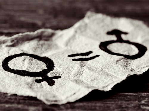 a female symbol, an equals sign and a male symbol drawn on a piece of paper depicting the women equality