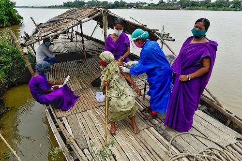 An old woman takes Covishield vaccination on a boat on the bank of the river Mundeshwari, Chitnan Village, West Bengal. India on June 29, 2021. Photo by Indranil Aditya/NurPhoto via Getty Images