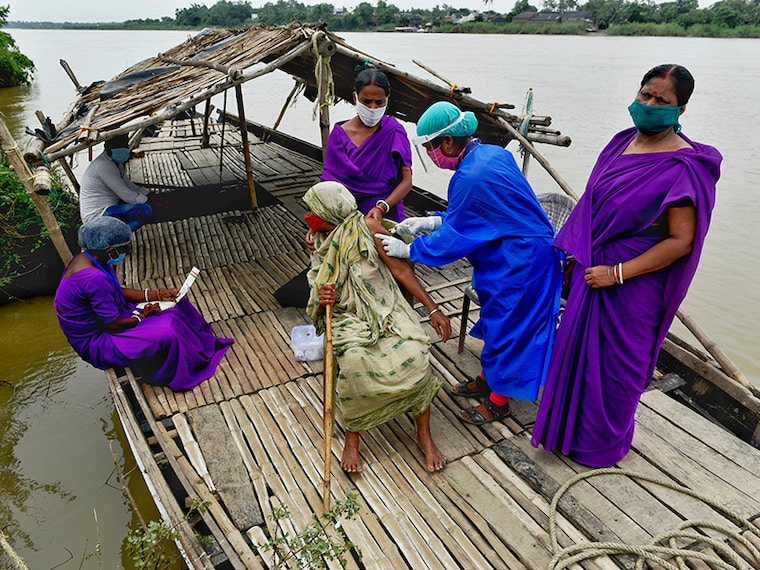 An old woman takes Covishield vaccination on a boat on the bank of the river Mundeshwari, Chitnan Village, West Bengal. India, 29 June, 2021. (Photo by Indranil Aditya/NurPhoto via Getty Images)