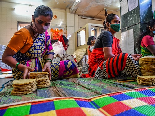 In this photograph taken on March 8, 2021, members of Shri Mahila Griha Udyog, the  organisation that produces the famous Lijjat Papad, arrange rolled papadums for delivery at one of the organisation's facilities in Mumbai. - The fairytale success of Lijjat Papad -- a multi-million-dollar venture founded by seven women in a crowded Mumbai tenement in 1959 with seed capital of 80 rupees (1.10  USD) -- belies its revolutionary feminist aspirations. - TO GO WITH India-economy-gender-food, FEATURE by Ammu KANNAMPILLY (Photo by Indranil MUKHERJEE / AFP) / TO GO WITH India-economy-gender-food, FEATURE by Ammu KANNAMPILLY (Photo by INDRANIL MUKHERJEE/AFP via Getty Images)