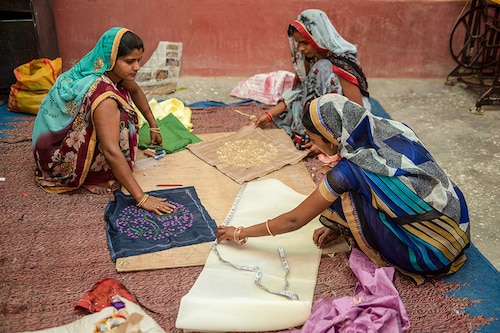 Indian rural village self employed women making cushion covers from recycled materials at a workshop in Varanasi, Uttar Pradesh, India. Image: Shutterstock