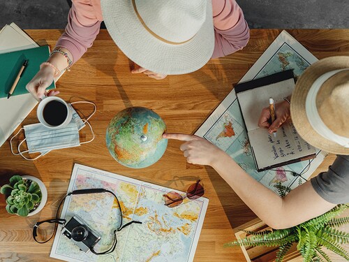 Top view of young couple with maps planning vacation trip holiday, desktop travel concept.