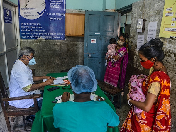 Women with their children wait inside a paediatric ward for a medical check up at a hospital in Siliguri on September 15, 2021, following a surge in fever and respiratory problems in children. (Photo by Diptendu DUTTA / AFP) (Photo by DIPTENDU DUTTA/AFP via Getty Images)