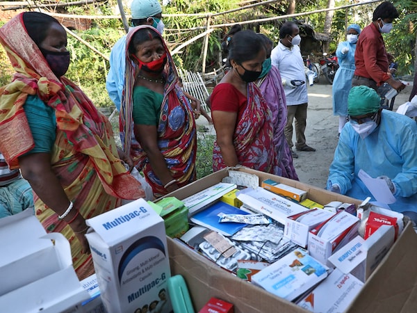 Villagers wait to receive medicine at a free medical camp set up to provide healthcare support to villagers, amidst the spread of the coronavirus disease COVID-19), at Debipur village in South 24 Parganas district in the eastern West Bengal state, India, May 21, 2021. REUTERS/Rupak De Chowdhuri - RC2BKN9ESXKV